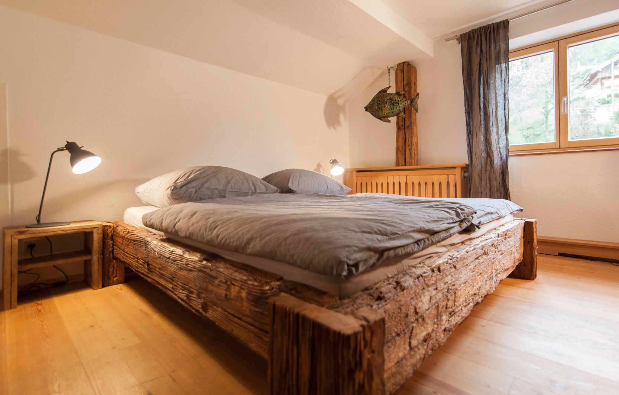 Hauptschlafzimmer mit massivem Altholzbett und antikem Schrank